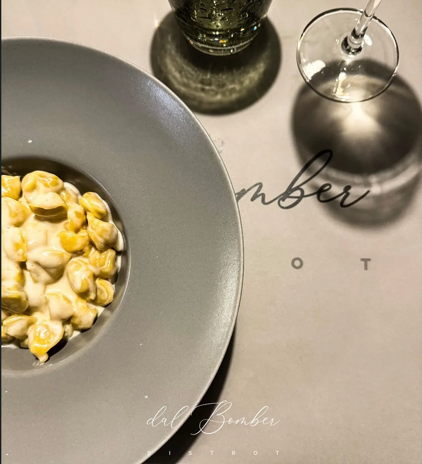 Tortellini in crema di parmigiano, con il calice e la tovaglietta Dal Bomber