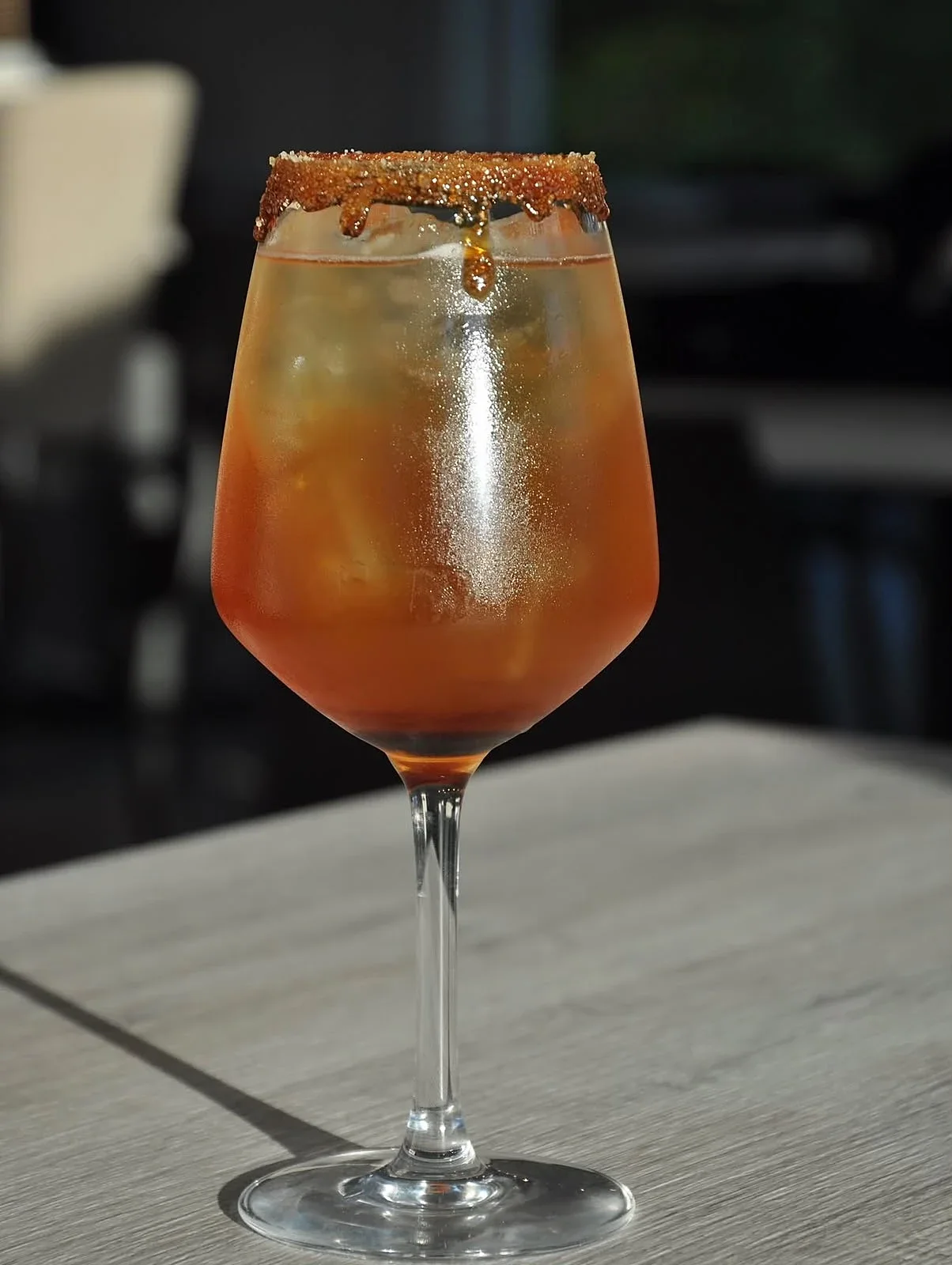 Cocktail ambrato con bordo di zucchero caramellato