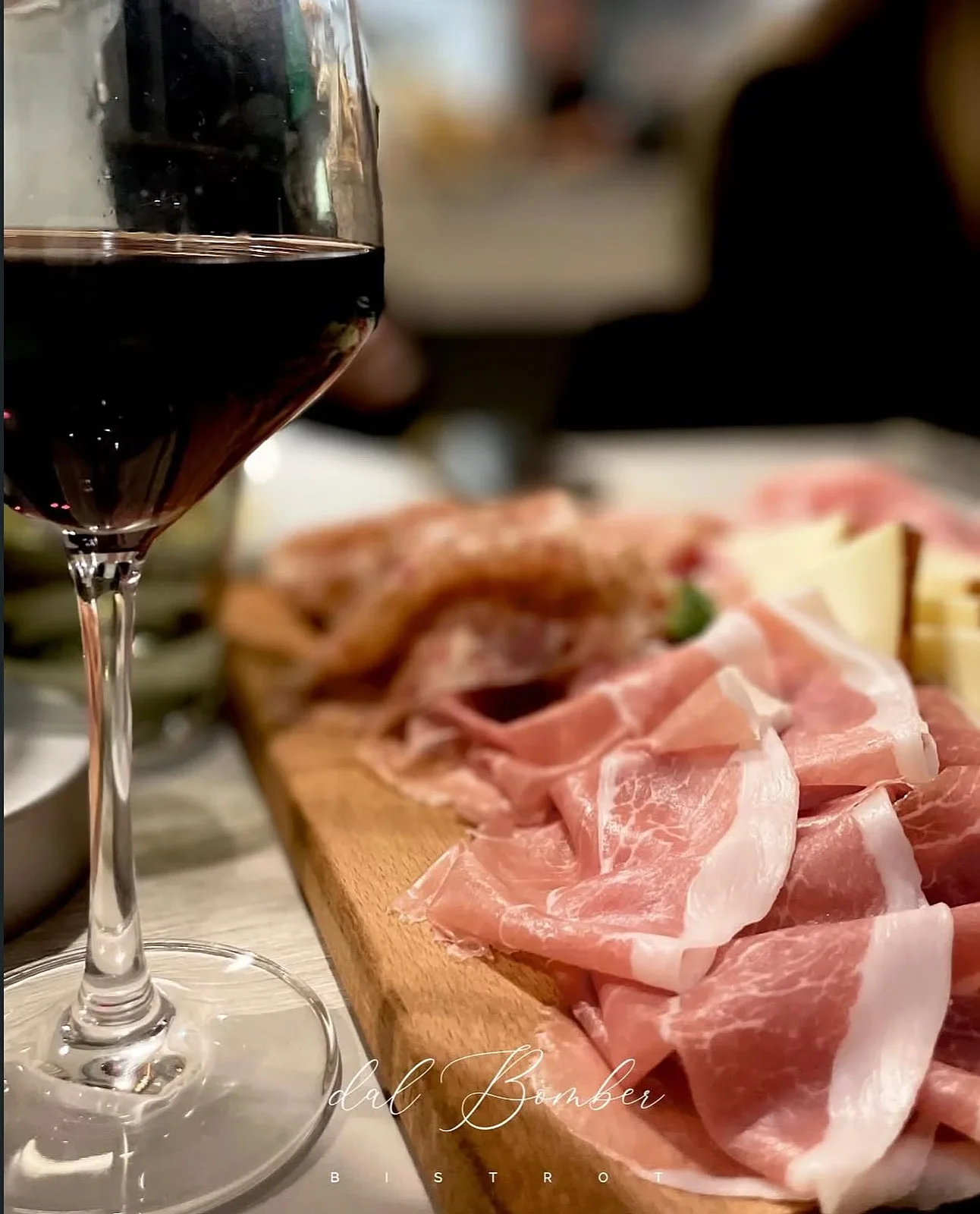 Tagliere di salumi e formaggi con un calice di rosso